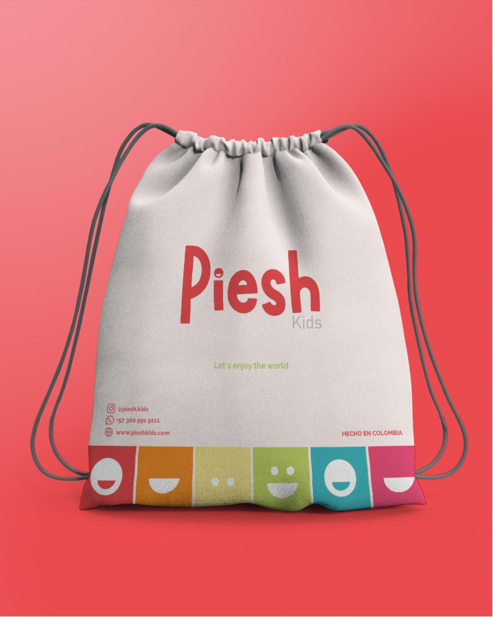 Bolso de tela de Piesh Kids con el logotipo, el lema Let's enjoy the world y una franja de caras de colores