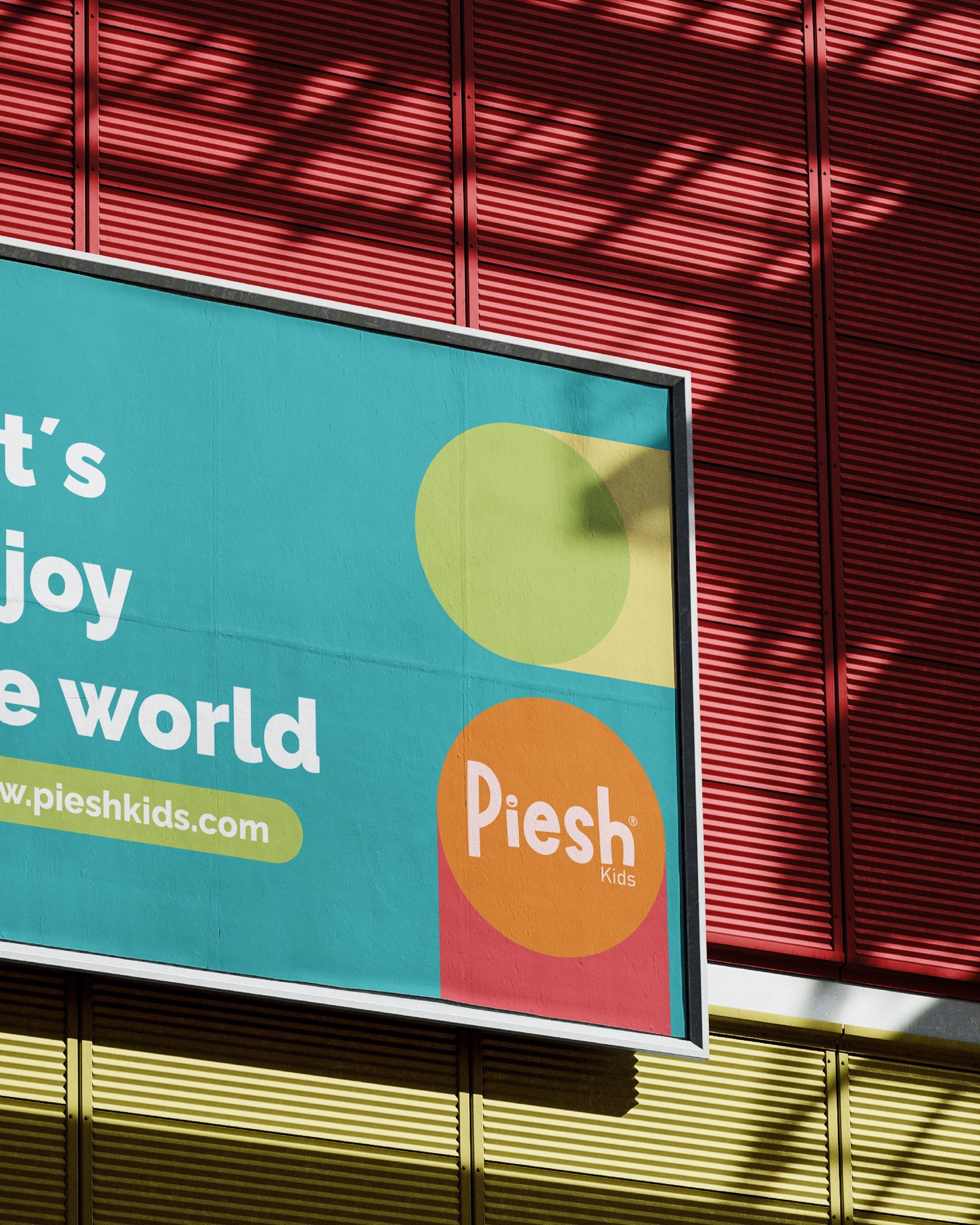 Valla de Piesh Kids, parte derecha: el lema Let's enjoy the world y el logotipo sobre un círculo naranja